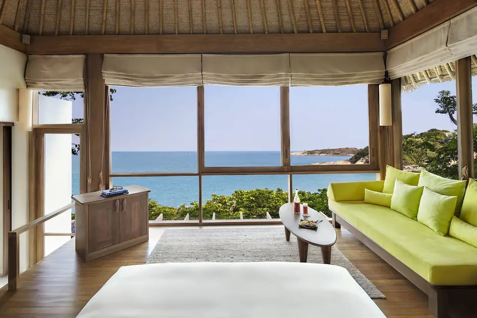 Horisontal udsigt over Six Senses Samui resort værelse med plys seng og panoramaudsigt over havet.