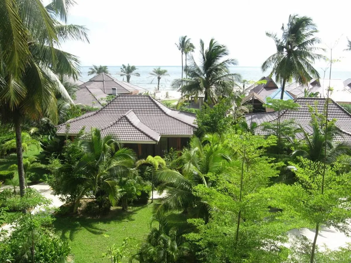 Udsigt over Sudala Beach Resorts lave bygninger og palmer med havet i baggrunden.