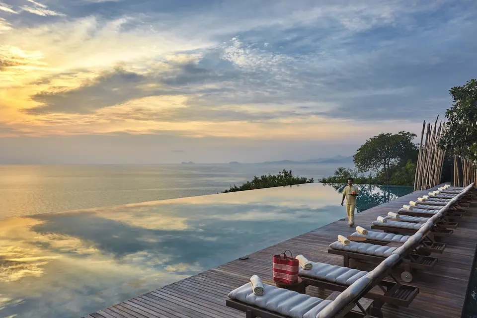 Strandresort med havudsigt og pool loungestole ved solnedgang