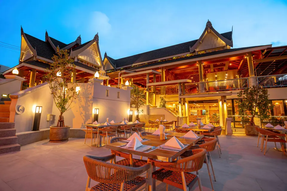 Cattleya Restaurant på Orchidacea Resort med opdækkede borde på terrassen i skumringen