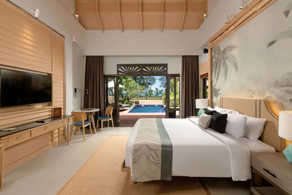 Lyst hotelværelse med stor seng og privat pool på Khaolak Merlin Resort, omgivet af frodig tropisk natur.
