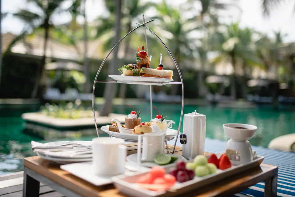 Eftermiddagste med kager og sandwiches ved poolkanten på Rest Detail Hotel Hua Hin, omgivet af afslappet feriestemning.