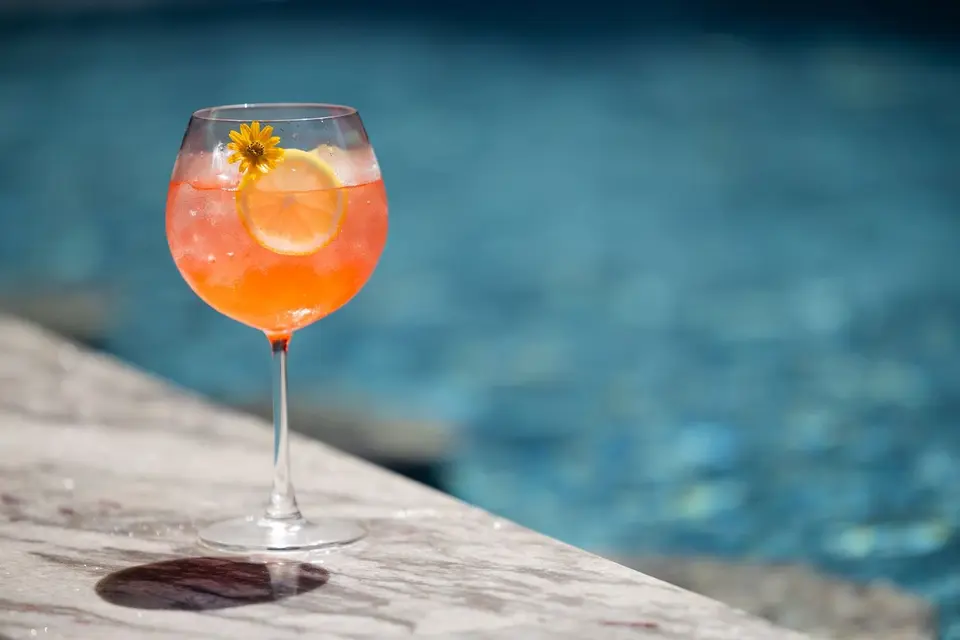 Farverig cocktail med citron og blomst på marmorbord ved poolen på Varana Hotel Krabi under afslappende feriestemning.