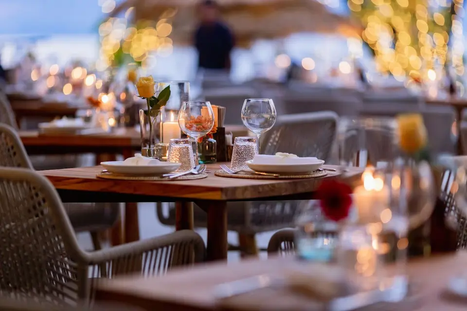 Aftenstemning på udendørs restaurant med dækkede borde og lyskæder på Varana Hotel i Krabi.