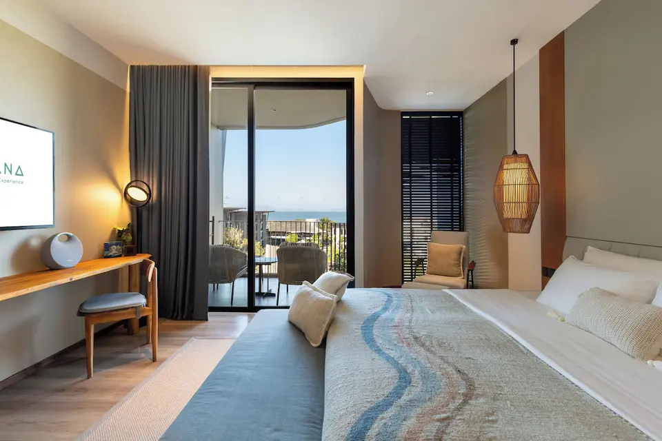 Lyst hotelværelse med stor seng og balkon med havudsigt på Varana Hotel Krabi.