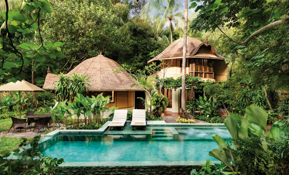 Eksotisk villa med stråtag og pool omgivet af grøn jungle på Rayavadee Krabi, perfekt til afslapning i tropiske omgivelser.