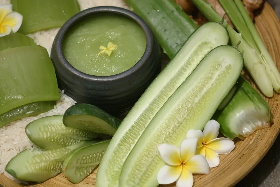 Traditionel thailandsk grøn karry med ris, friske grøntsager og blomsterserveret på træfad i eksotiske omgivelser ved Krabi.