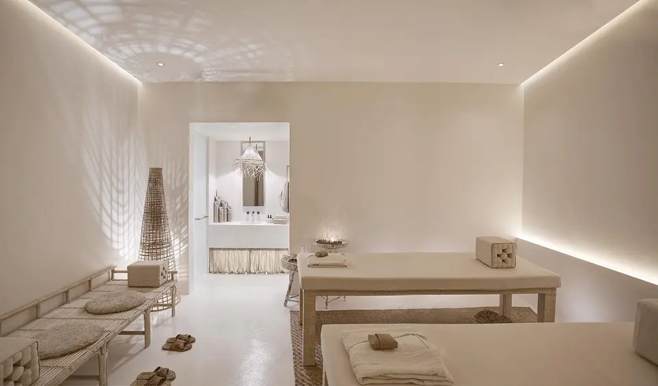 Roligt spa-rum på Raya Heritage i Chiang Mai med massageborde, bløde naturfarver og udsigt til badeværelset.