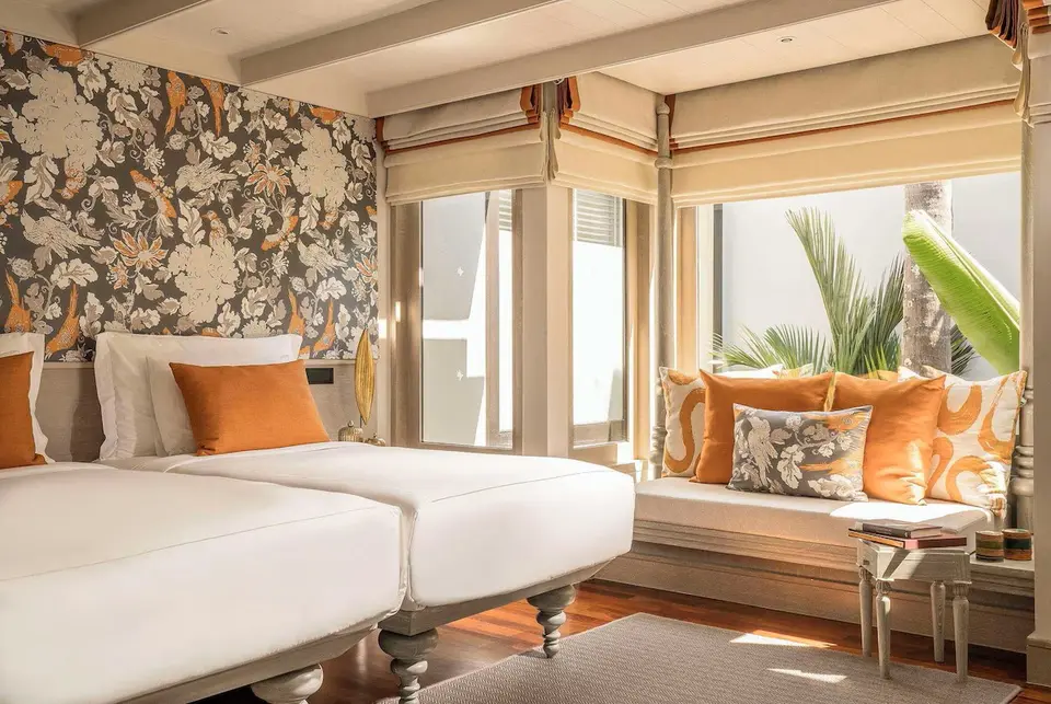 Lyst soveværelse med enkeltsenge og store med udsigt til palmer på luksuriøse vinduer Phuket-resort.