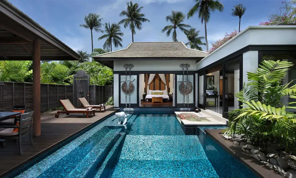 Eksklusiv villa med privat pool og tropisk have under blå himmel i Phuket, perfekt til afslappende ferie.