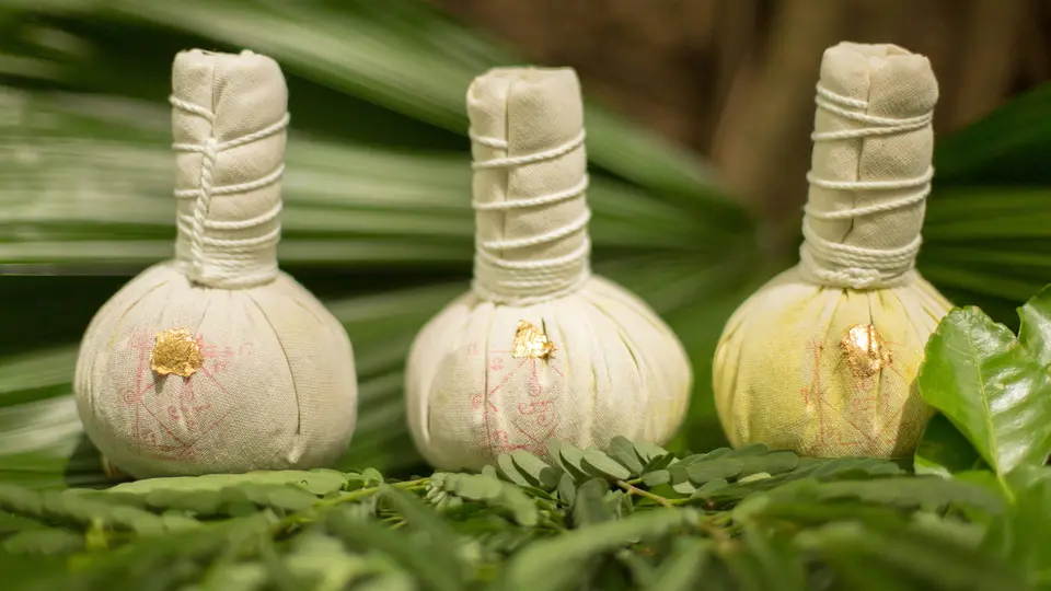 Tre hvide urtebolde på grønne blade skaber rolig spa-stemning på Four Seasons Resort Koh Samui.