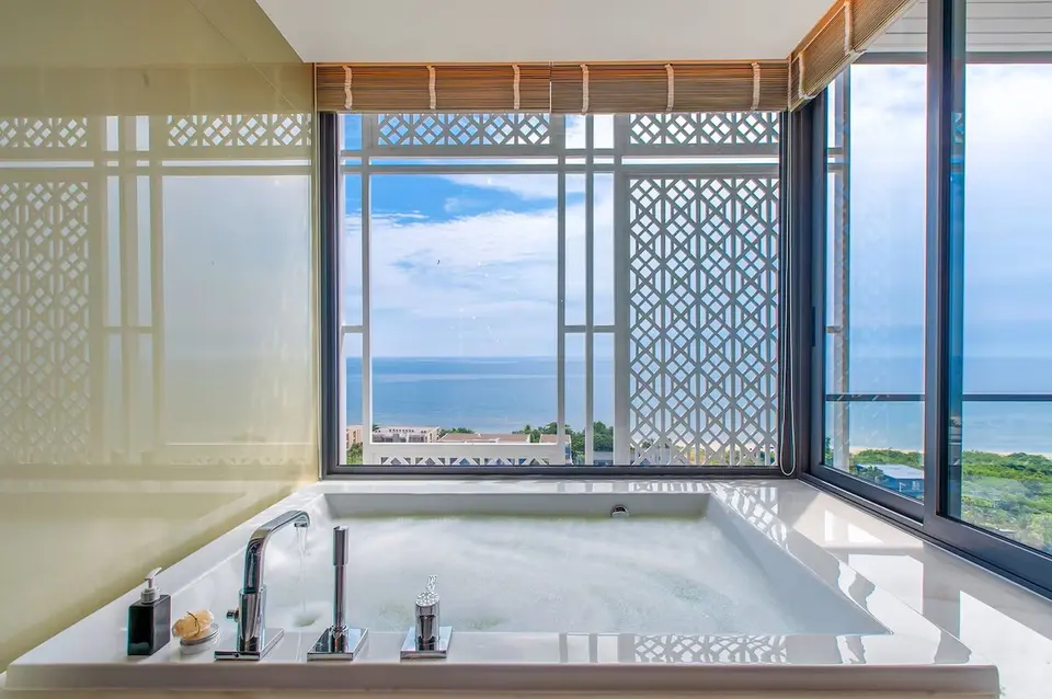 Luksuriøs poolvilla på Baba Beach Club Hua Hin med stort badekar og panoramaudsigt over havet og blå himmel.