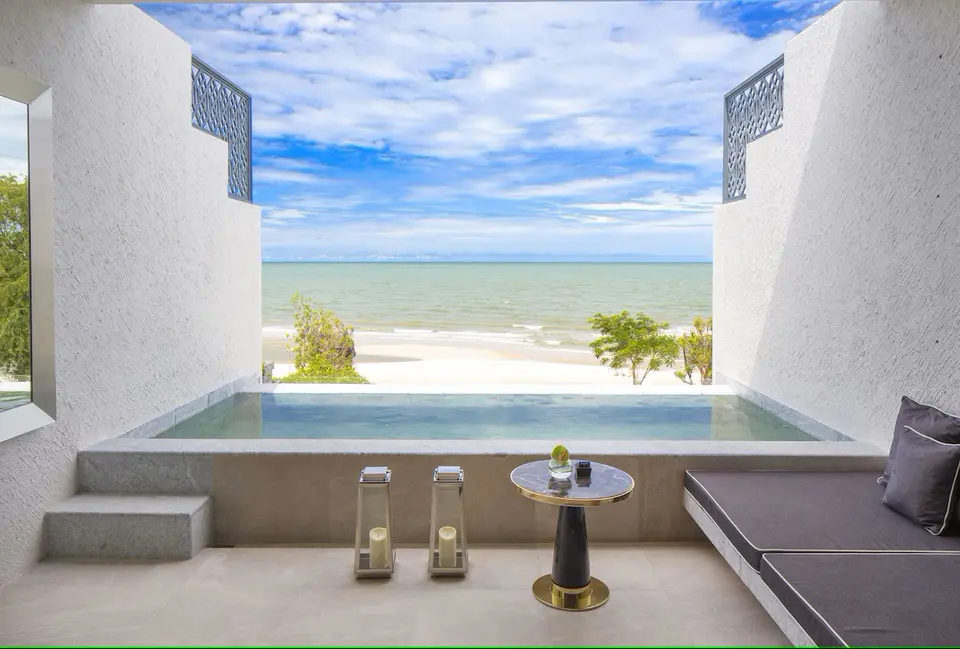 Moderne terrasse på Baba Beach Club i Hua Hin med udsigt til rolig sandstrand, hav og afslappet stemning.