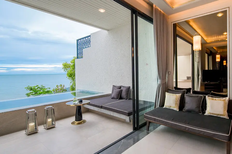 Elegant poolvilla med sorte sofaer og lanterner på terrasse med havudsigt ved Baba Beach Club Hua Hin i solskinsvejr.