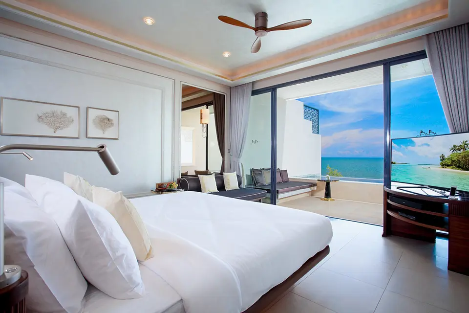 Elegant hotelværelse på Baba Beach Club Hua Hin med havudsigt, stor seng og balkon i afslappende, luksuriøse omgivelser.