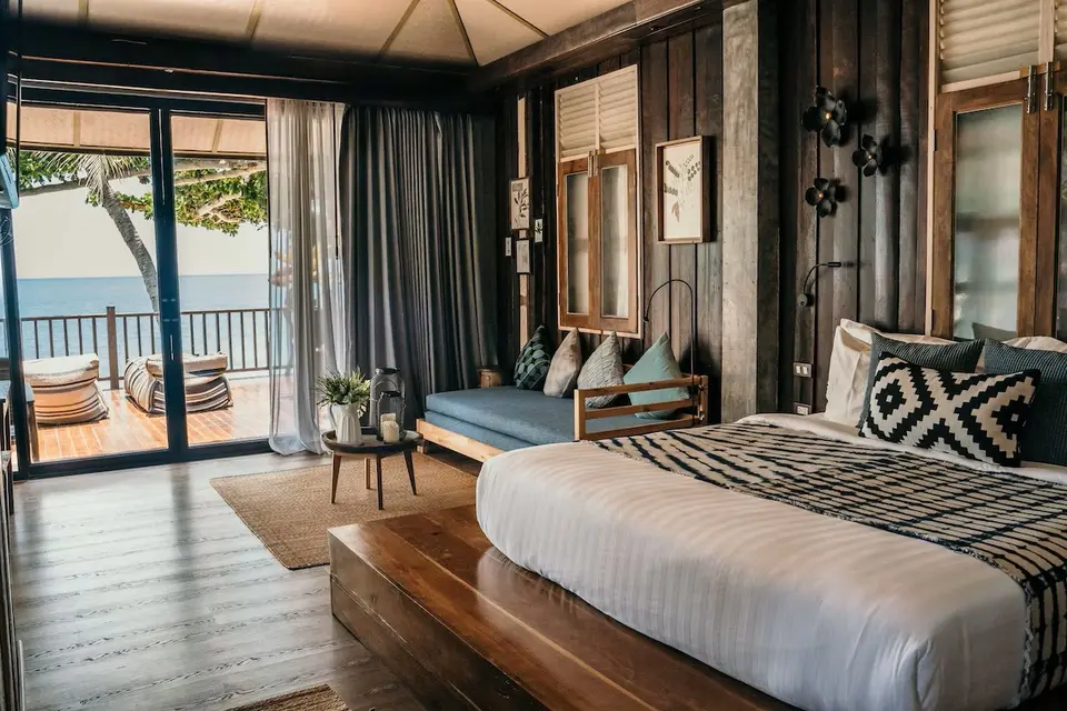 Lyst Beach Loft-hotelværelse på Bali med stor seng, loungeområde og panoramaudsigt til havet fra privat terrasse.
