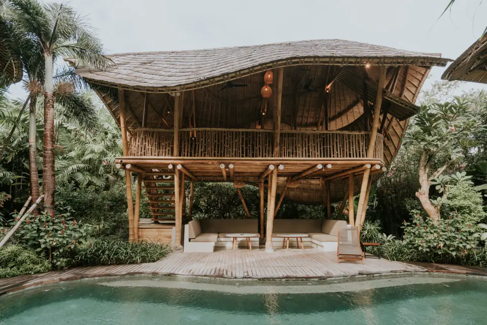Bambuspavillon med siddepladser ved poolen på ZIN Canggu