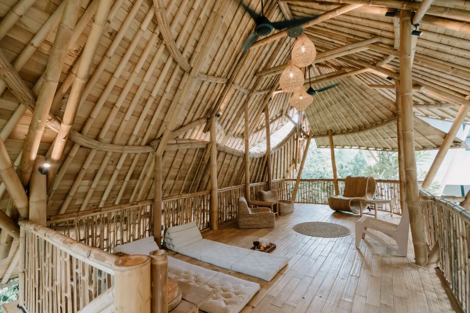 Lounge på ZIN Canggu med bambustag, liggehynder og flettede stole.