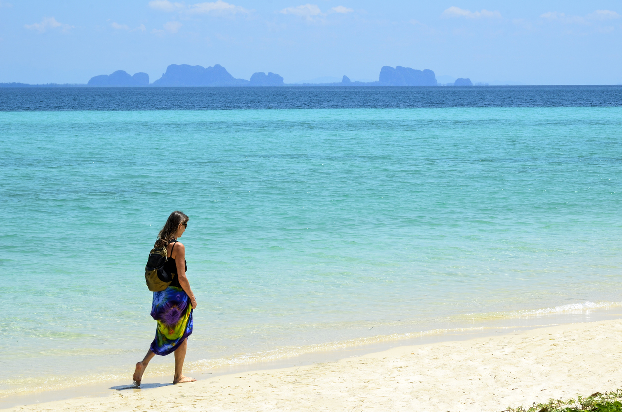 Kvinde går på stranden i Thailand