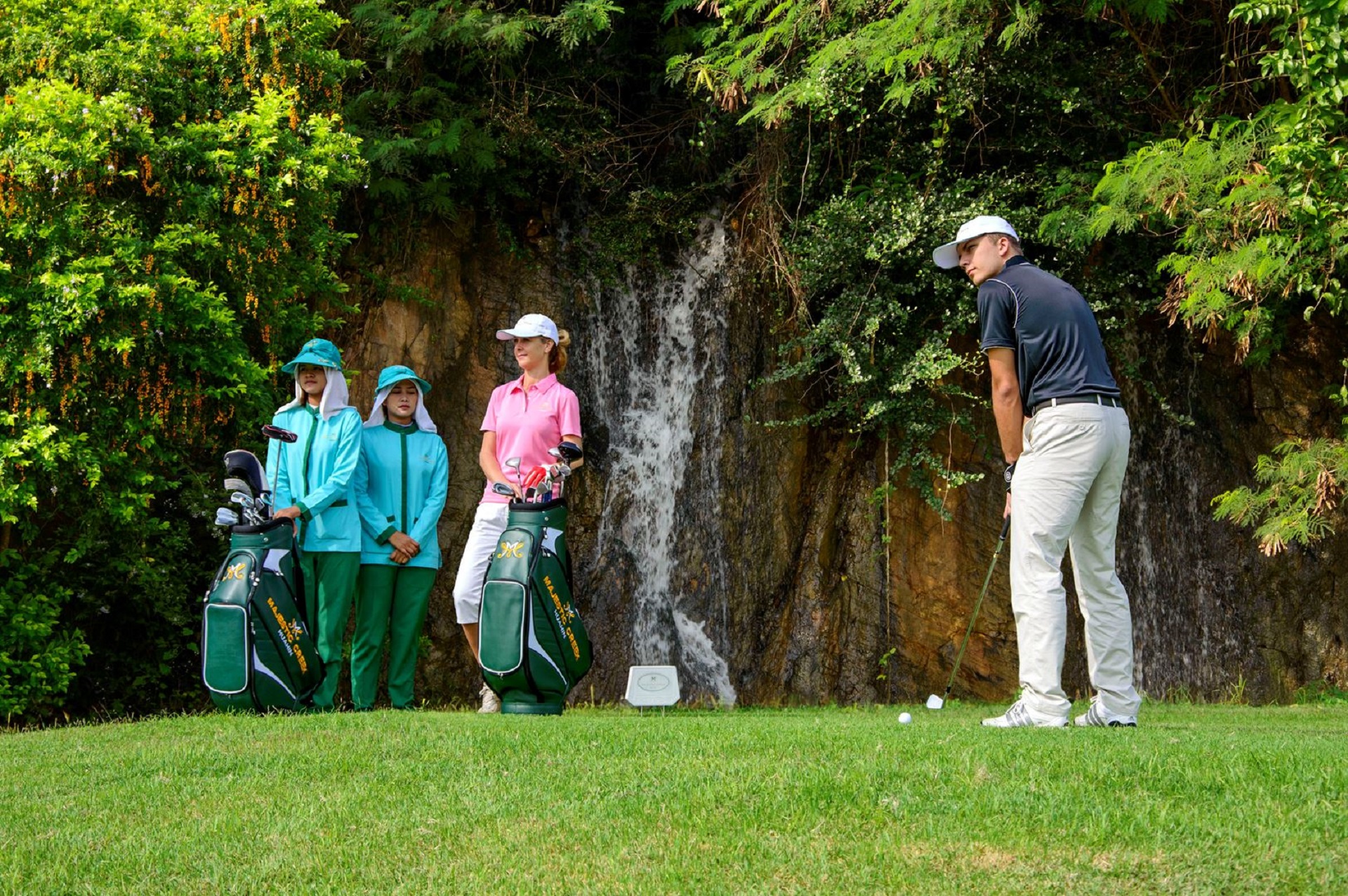 Mennesker der spiller golf på Majestic Creek Golf & Country Club ved vandfald