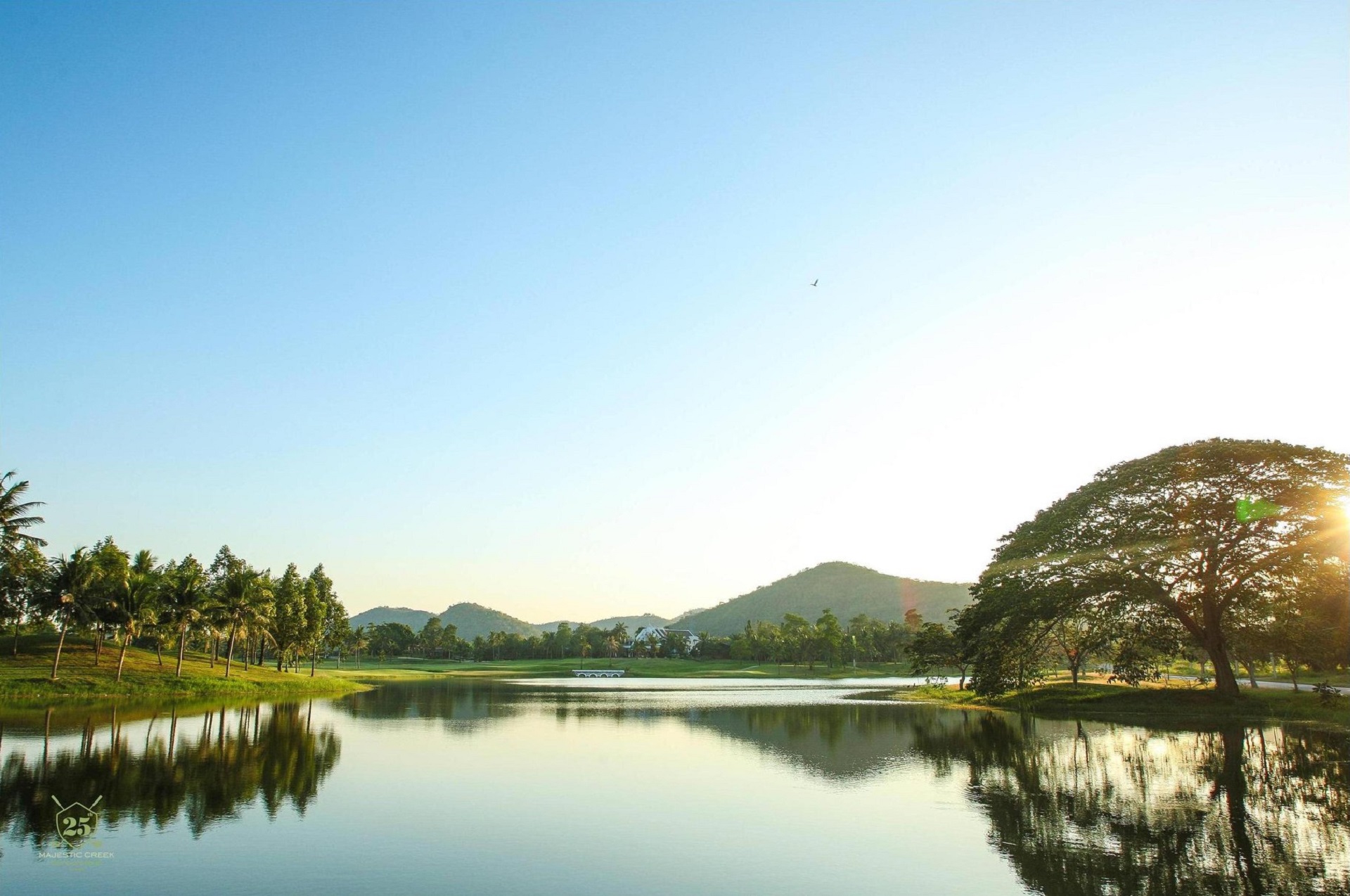 Majestic Creek Golf & Country Club Hua Hin, sø omgivet af grønt græs og høje træer